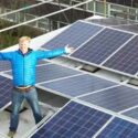 Man standing on roof with solar panels
